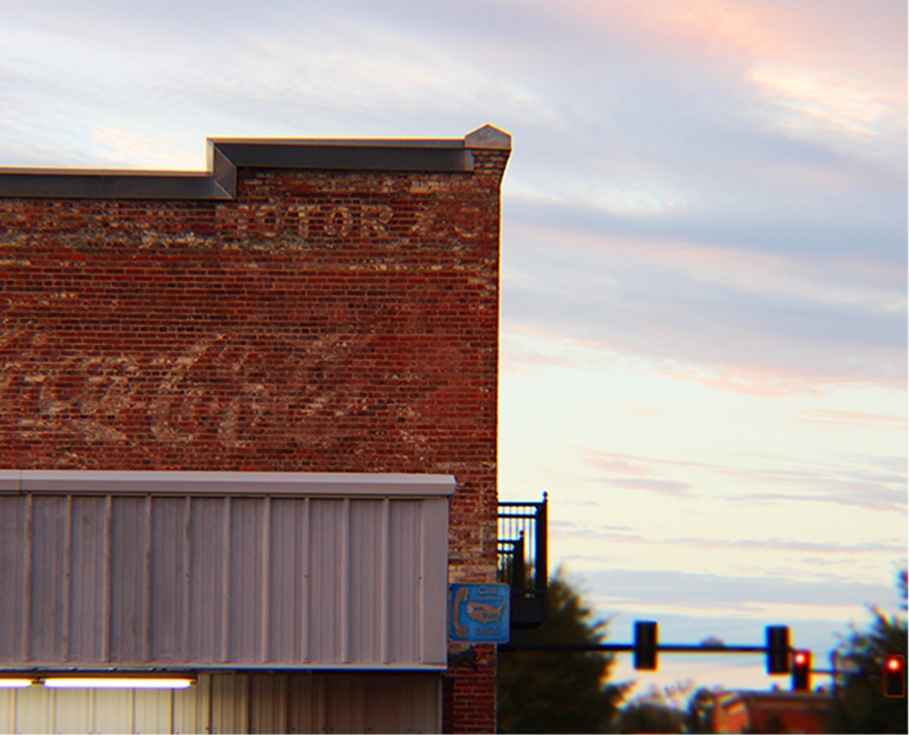 old brick building with coca-cola painted on the side and payphone sign
