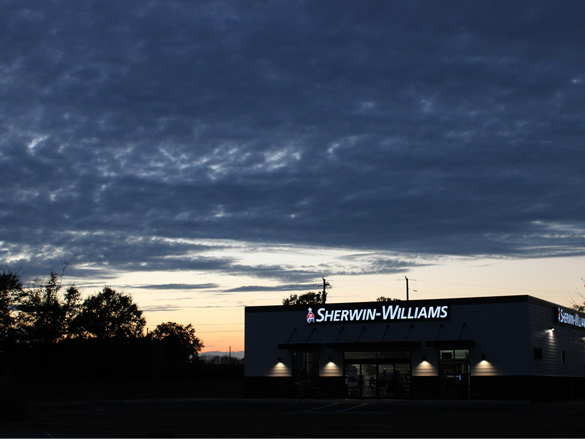 golden hour sunset behind a sherwin-williams building