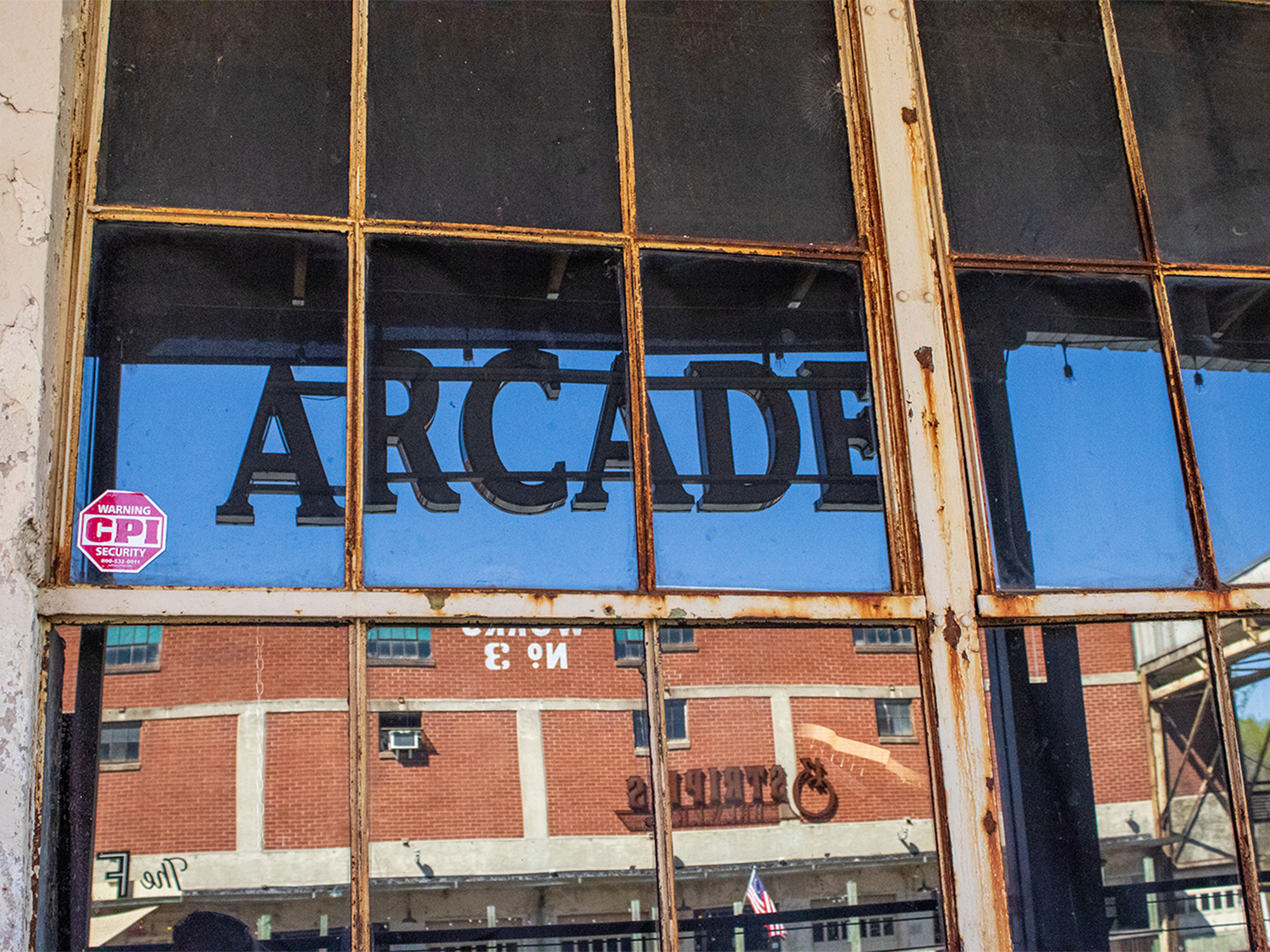 arcade sign reflected in window of old paper mill