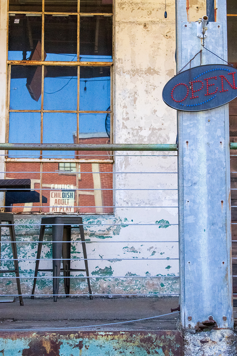 outdoor seating area with open sign at old paper mill